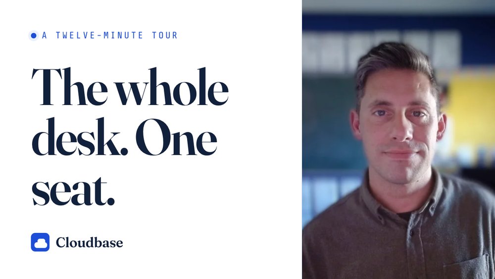 Man in an office setting next to text reading "The whole desk. One seat." advertising Cloudbase's twelve-minute tour.